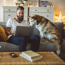 Man working on laptop with his dog