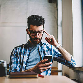 confused man looking at mobile phone